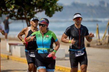 Demir Adam 70.3 Lima 'nın son turlarında koşan sporcular, sadece hayaller peşinde koşmakla kalmaz, aynı zamanda yaşarlar da. Gözyaşları, ter ve kırılmaz ruh bitiş çizgisine giden yolu işaretler..