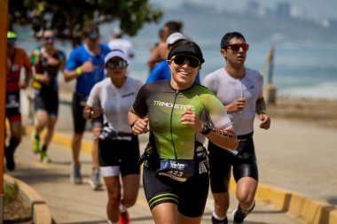 Demir Adam 70.3 Lima 'nın son turlarında koşan sporcular, sadece hayaller peşinde koşmakla kalmaz, aynı zamanda yaşarlar da. Gözyaşları, ter ve kırılmaz ruh bitiş çizgisine giden yolu işaretler..