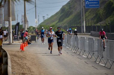 Demir Adam 70.3 Lima 'nın son turlarında koşan sporcular, sadece hayaller peşinde koşmakla kalmaz, aynı zamanda yaşarlar da. Gözyaşları, ter ve kırılmaz ruh bitiş çizgisine giden yolu işaretler..