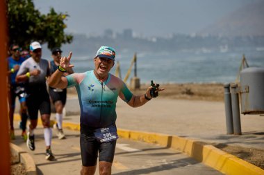 Demir Adam 70.3 Lima 'nın son turlarında koşan sporcular, sadece hayaller peşinde koşmakla kalmaz, aynı zamanda yaşarlar da. Gözyaşları, ter ve kırılmaz ruh bitiş çizgisine giden yolu işaretler..