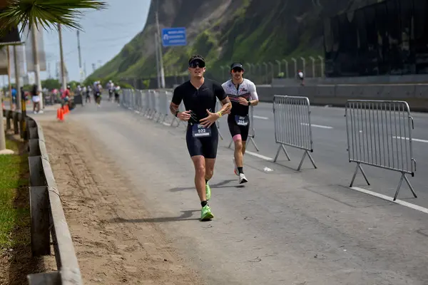 Demir Adam 70.3 Lima 'nın son turlarında koşan sporcular, sadece hayaller peşinde koşmakla kalmaz, aynı zamanda yaşarlar da. Gözyaşları, ter ve kırılmaz ruh bitiş çizgisine giden yolu işaretler..