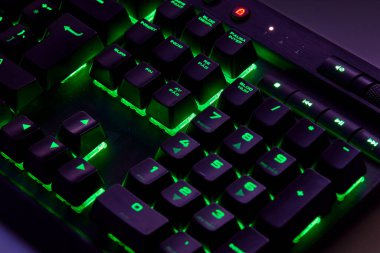 Renkli bir RGB mekanik oyun klavyesinin yakın çekimi canlı renklerle aydınlatılmış. Oyun ayarları için tasarlanmış modern bilgisayar aksesuarı, kişiselleştirilebilir arka ışıklandırma ve şık tasarım. 