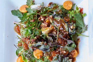 Andean yeşillikleri, altın böğürtlenler (aguaymanto) ve zengin yerel soslu geleneksel Cusco tarzı salata. Peru lezzetlerini vurgulayan taze, organik bileşenlerin canlı bir birleşimi.