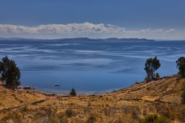 Taquile Adası 'nın yüksek yamaçlarından Titicaca Gölü bu yüksek irtifa harikasının muazzam güzelliğini ve dinginliğini gözler önüne seriyor. Ufka uzanan derin mavi sular ve And Işığı döküm.