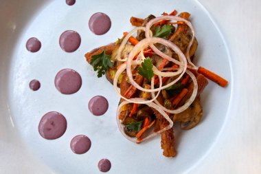 İçinde sotelenmiş mantarlar, yerli patatesler, havuçlar ve soğanlar bulunan rafine edilmiş bir Cusco tarzı yemek. Mor mısır redüksiyonu ustalıkla sunuluyor. Gelenek zarafetle buluşur.