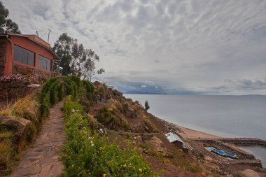 Capachica Yarımadası 'nda, çiçeklerin sıcacık göl kenarındaki bir evi ve taş bankları kucakladığı huzurlu bir köşe sizi Titicaca Gölü' nün muazzam güzelliğini durup takdir etmeye davet ediyor. Puno Peru