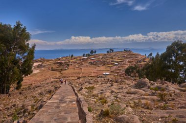 Taquile Adası 'nın yüksek yamaçlarından Titicaca Gölü bu yüksek irtifa harikasının muazzam güzelliğini ve dinginliğini gözler önüne seriyor. Ufka uzanan derin mavi sular ve And Işığı döküm.