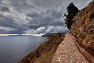 Taquile Adası 'nın yüksek yamaçlarından Titicaca Gölü bu yüksek irtifa harikasının muazzam güzelliğini ve dinginliğini gözler önüne seriyor. Ufka uzanan derin mavi sular ve And Işığı döküm.