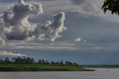 Pacaya Samiria Doğal Rezervi 'nin kalbinin derinliklerinde, Maran Nehri' ndeki yüksek fırtına bulutlarının altında yalnız bir tekne sürükleniyor. Loreto Peru.