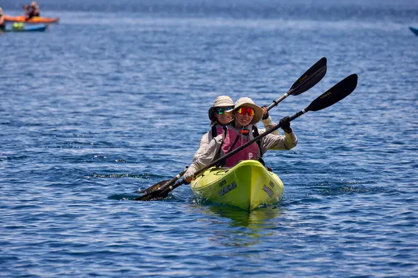 Bir grup deniz kayakçısı And Dağları 'nın engin, yüksek irtifa güzelliği ile çevrili Titicaca Gölü' nün derin mavi sularında huzur içinde süzülüyor. Puno Peru.