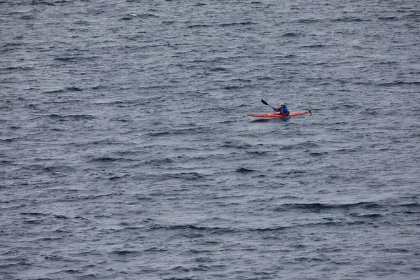 Bir grup deniz kayakçısı And Dağları 'nın engin, yüksek irtifa güzelliği ile çevrili Titicaca Gölü' nün derin mavi sularında huzur içinde süzülüyor. Puno Peru.