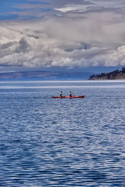 Bir grup deniz kayakçısı And Dağları 'nın engin, yüksek irtifa güzelliği ile çevrili Titicaca Gölü' nün derin mavi sularında huzur içinde süzülüyor. Puno Peru.