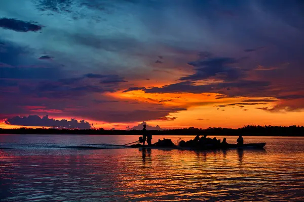 Kudretli Amazonas Nehri 'nin üzerinde altın saat büyüsü var. Gökyüzü alevli renklerle parıldıyor ve doğada ihtişam sahne alıyor. Ormanın kalbinde bir güne nefes kesici bir son