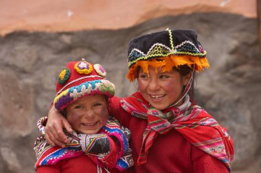 Andean gururunun, kimliğinin ve kültürel sürekliliğinin sembolleri olan canlı geleneksel Cusco kostümleri giymiş çocuklar. Gülüşleri ve renkleri sayesinde And Dağları 'nın ruhu parlıyor..