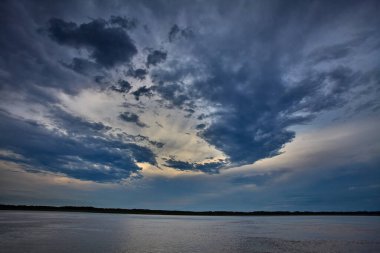 Gökyüzü güçlü Amazon fırtına bulutlarının üzerinde kükrer, rüzgarlar yükselir ve doğa bize ormanı kimin yönettiğini hatırlatır. Iquitos sularının üzerinde dramatik bir an.