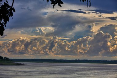 Gökyüzü güçlü Amazon fırtına bulutlarının üzerinde kükrer, rüzgarlar yükselir ve doğa bize ormanı kimin yönettiğini hatırlatır. Iquitos sularının üzerinde dramatik bir an.