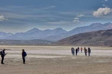 Bir grup gezgin, volkanlar, tuz düzlükleri ve sessizlikle çevrili Laguna Salinasas 'ın saf güzelliğini içine çekiyor. Unutulmaz bir durak.