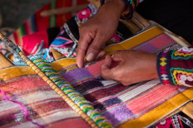 Bir dokumacının elleri, nesiller boyu yetenek, sabır ve yaratıcılık barındırır. Basit iplikleri sanat eserlerine dönüştürür. Her dokuma bir yolculuktur, her düğüm bir anıdır. Chinchero Cusco Peru.