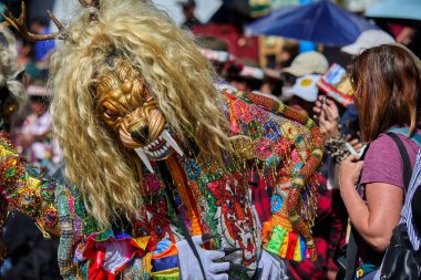 Şeytani maskeler ve akrobatik yeteneklerle, Saqras Paucartambo 'da dans ediyor, neşeli, alaycı ruhlar koruyor ve kışkırtıyor, enerji ve gerilim ekliyor. Bakire del Carmen