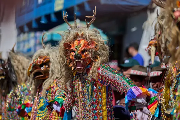 Şeytani maskeler ve akrobatik yeteneklerle, Saqras Paucartambo 'da dans ediyor, neşeli, alaycı ruhlar koruyor ve kışkırtıyor, enerji ve gerilim ekliyor. Bakire del Carmen