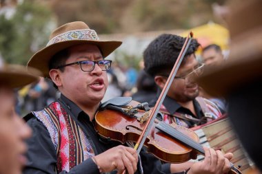 Tutkulu kemancı, Paucartambo, Peru 'daki canlı Virgen del Carmen kutlamalarında müzik ve geleneklere daldı.