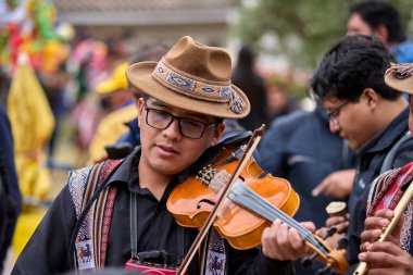 Tutkulu kemancı, Paucartambo, Peru 'daki canlı Virgen del Carmen kutlamalarında müzik ve geleneklere daldı.
