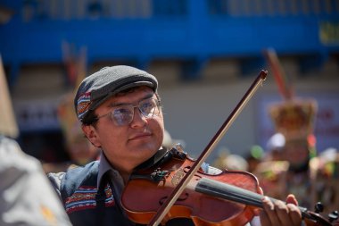 Tutkulu kemancı, Paucartambo, Peru 'daki canlı Virgen del Carmen kutlamalarında müzik ve geleneklere daldı.