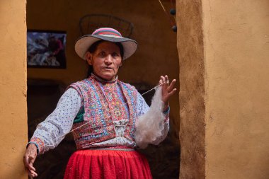 Colca Vadisi 'nin kalbinde gelenek devam ediyor. Bu kadın, kendi kültürünün canlı nakışı gibi giyinmiş, nesilden nesile geçen atalarından kalma tekniklerle yün örüyor..