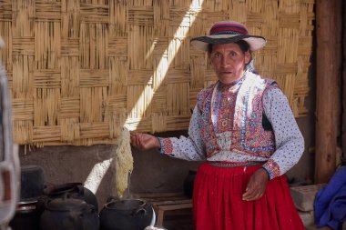 Colca Vadisi 'nin kalbinde gelenek devam ediyor. Bu kadın, kendi kültürünün canlı nakışı gibi giyinmiş, nesilden nesile geçen atalarından kalma tekniklerle yün örüyor..