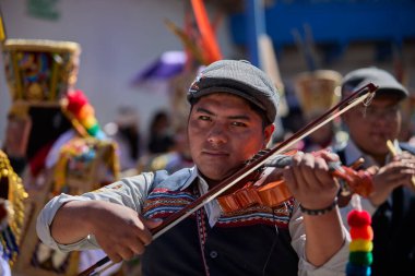 Tutkulu kemancı, Paucartambo, Peru 'daki canlı Virgen del Carmen kutlamalarında müzik ve geleneklere daldı.