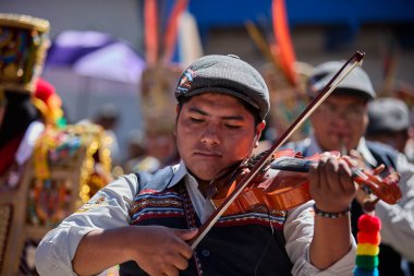 Tutkulu kemancı, Paucartambo, Peru 'daki canlı Virgen del Carmen kutlamalarında müzik ve geleneklere daldı.