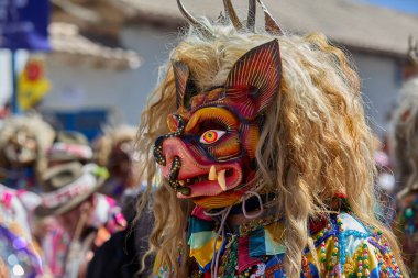 Şeytani maskeler ve akrobatik yeteneklerle, Saqras Paucartambo 'da dans ediyor, neşeli, alaycı ruhlar koruyor ve kışkırtıyor, enerji ve gerilim ekliyor. Bakire del Carmen
