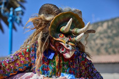 Şeytani maskeler ve akrobatik yeteneklerle, Saqras Paucartambo 'da dans ediyor, neşeli, alaycı ruhlar koruyor ve kışkırtıyor, enerji ve gerilim ekliyor. Bakire del Carmen