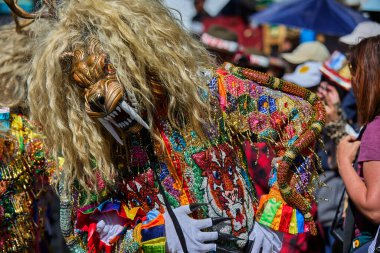 Şeytani maskeler ve akrobatik yeteneklerle, Saqras Paucartambo 'da dans ediyor, neşeli, alaycı ruhlar koruyor ve kışkırtıyor, enerji ve gerilim ekliyor. Bakire del Carmen