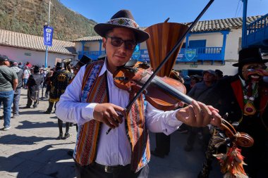 Tutkulu kemancı, Paucartambo, Peru 'daki canlı Virgen del Carmen kutlamalarında müzik ve geleneklere daldı.