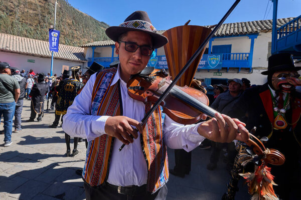 Passionate violinist performing at the vibrant Virgen del Carmen celebrations in Paucartambo, Peru, immersed in music and tradition