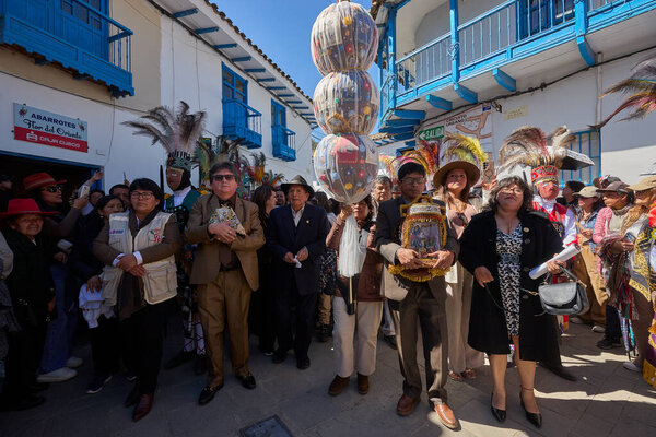 The solemn procession of La Virgen del Carmen emerges from the church in Paucartambo, surrounded by faithful devotees, music, and centuries-old tradition