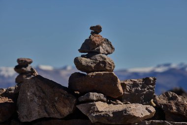 Taş apachetalar, görkemli Ampato 'nun ve Sabancaya volkanlarının, And maneviyatının sembollerinin ve ebedi geleneğin arkaplanına karşı antik bir adak olarak dururlar.