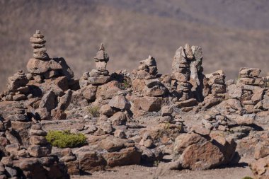 Taş apachetalar, görkemli Ampato 'nun ve Sabancaya volkanlarının, And maneviyatının sembollerinin ve ebedi geleneğin arkaplanına karşı antik bir adak olarak dururlar.