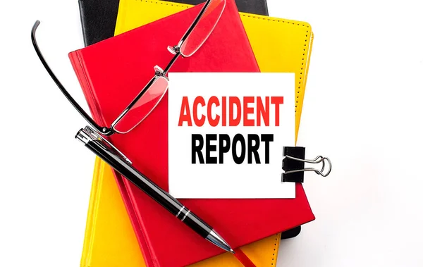 ACCIDENT REPORT text written on sticky on colorful notebooks