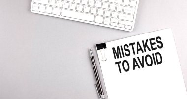 Gri arkaplan üzerinde klavye olan bir kağıt üzerinde Hatalar Yapılacak