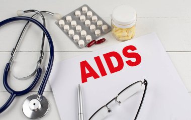 Steteskoplu ve haplı bir kağıtta AIDS kelimesi