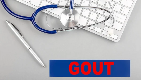 stock image GOUT word with Stethoscope on a keyboard on grey background