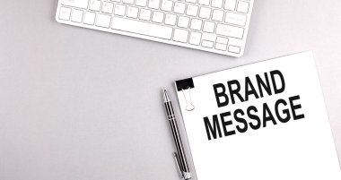 Gri arkaplan üzerinde klavye olan bir kağıt üzerinde Brand MESSAGE metni