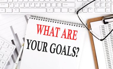 Beyaz arkaplanda klavye, not defteri ve analiz çizelgesi bulunan ofis masasındaki hedefleriniz nelerdir?.