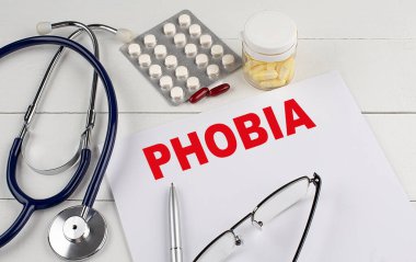 Steteskoplu ve haplı bir kağıtta PHOBIA kelimesi