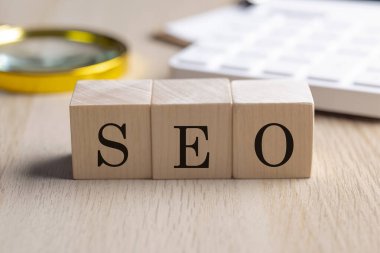 Tahta küplerde SEO, büyüteç ve hesap makinesi, finansal konsept arka planı.