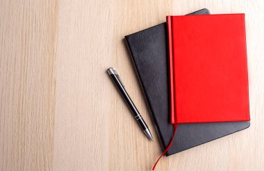 Siyah-kırmızı defterli ofis masası. Düz konum, üst görünüm, kopyala
