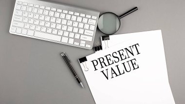 Klavye, büyüteç ve kalemle birlikte bir kağıdın üzerinde hediye olarak VALUE metni. İş konsepti