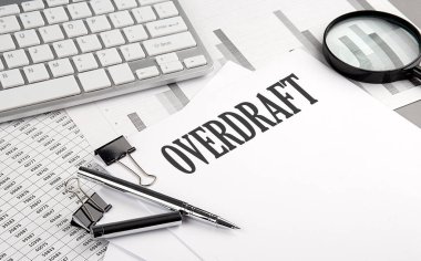 Grafikli ve klavyeli bir kağıt üzerinde OVERDRAFT metin, iş konsepti